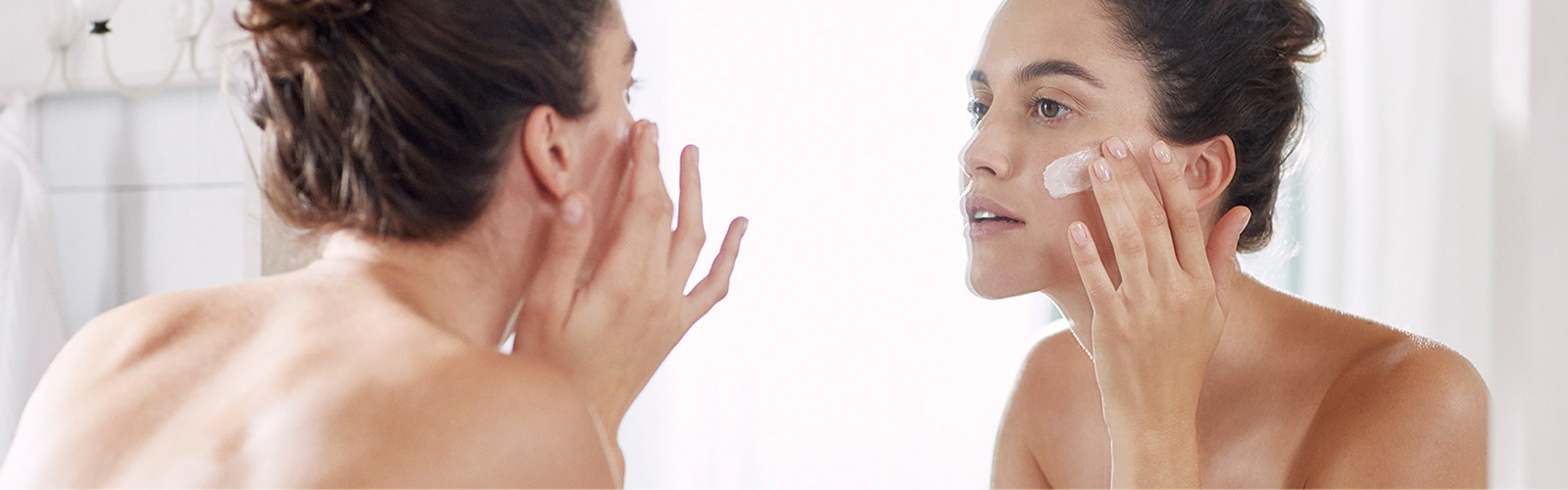 Woman moisturizing her face