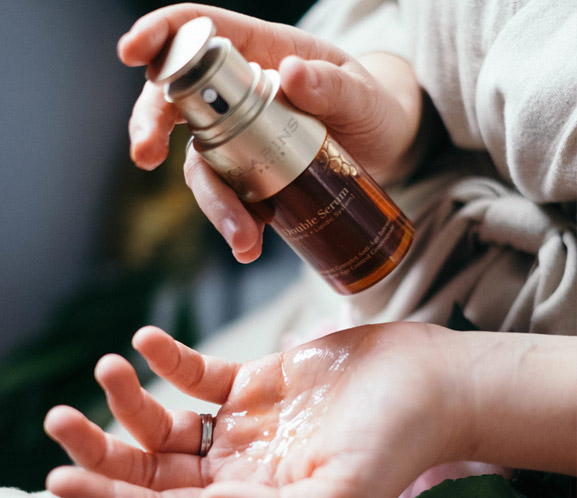 Clarins user dispensing Double Serum into hands