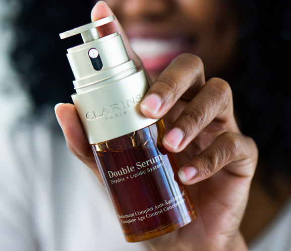 Clarins user holding Double Serum in front of face