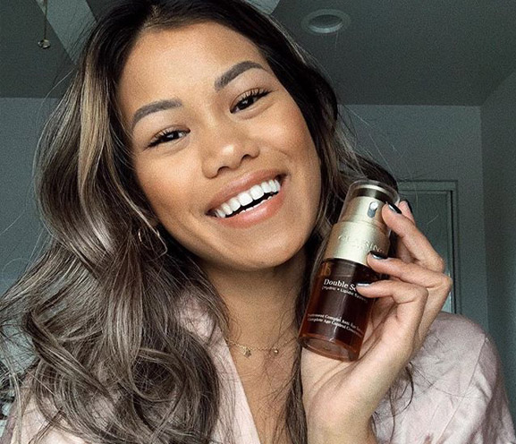 Clarins user holding Double Serum by face