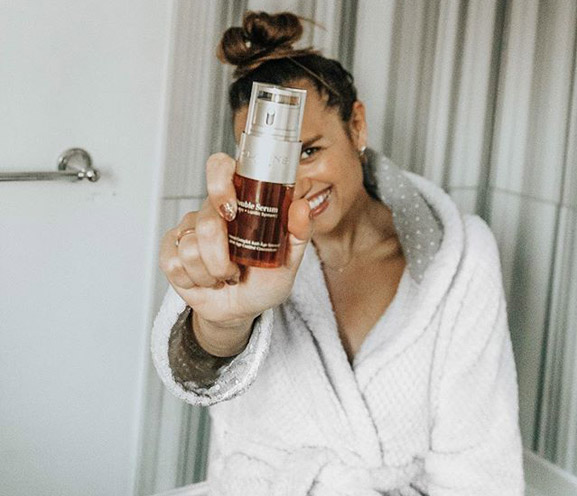 Clarins user holding Double Serum in front of face